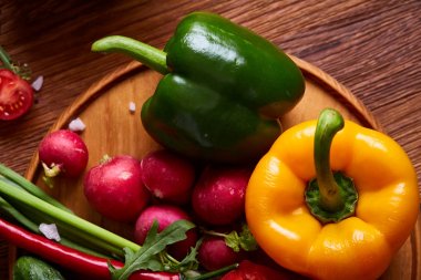 Yaratıcı taze sebze salatası ruccola, salatalık, domates ve beyaz plaka, seçici odak üzerinde raddish