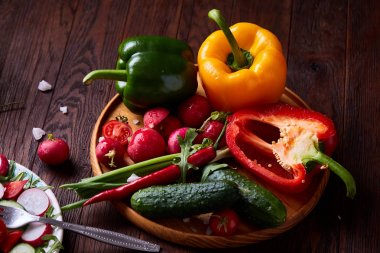 Yaratıcı taze sebze salatası ruccola, salatalık, domates ve beyaz plaka, seçici odak üzerinde raddish