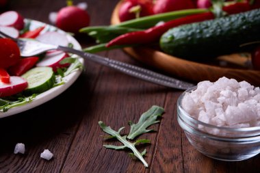 Yaratıcı taze sebze salatası ruccola, salatalık, domates ve beyaz plaka, seçici odak üzerinde raddish