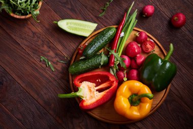 Yaratıcı taze sebze salatası ruccola, salatalık, domates ve beyaz plaka, seçici odak üzerinde raddish