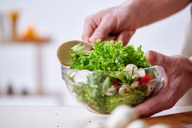 Adam seçici odak sağlıklı sebze salatası, yakın çekim, yapım mutfak yemek.