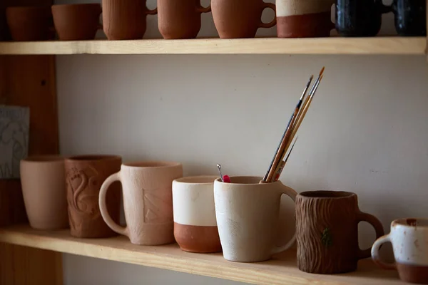 Différentes poteries artisanales sur une étagère en bois, gros plan, mise au point sélective . — Photo