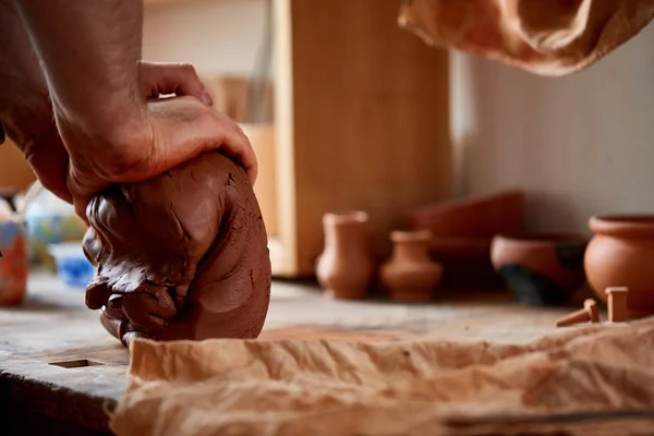 Mãos de oleiro macho moldando uma argila em oficina de cerâmica, close-up, foco seletivo — Fotografia de Stock