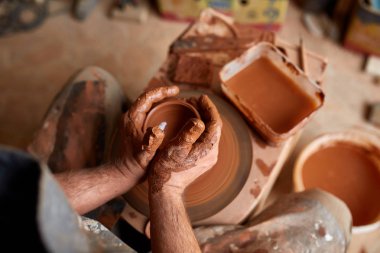 Çamurdan, seçici odak yakın çekim eller erkek Potter önlük kalıpları içinde kase