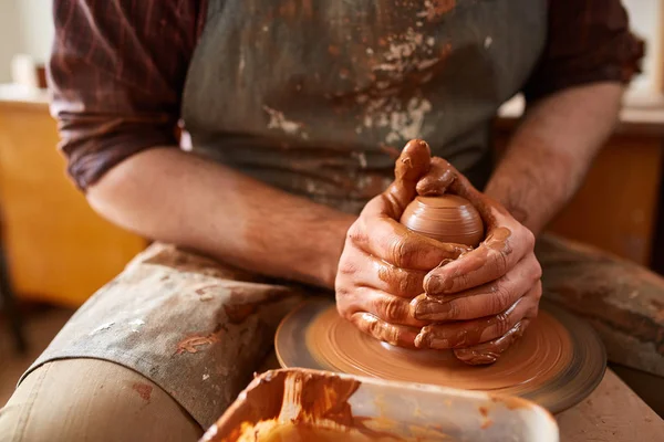 Närbild händerna på en manlig potter i förkläde som gör en vas från lera, selektivt fokus — Stockfoto