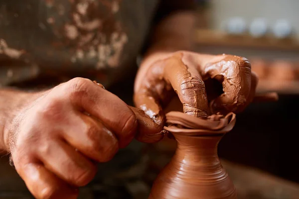 Närbild händerna på en manlig potter i förkläde som gör en vas från lera, selektivt fokus — Stockfoto