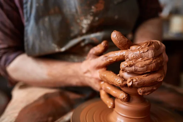 En manlig potter i förkläde formar skål från lera, selektivt fokus, närbild — Stockfoto