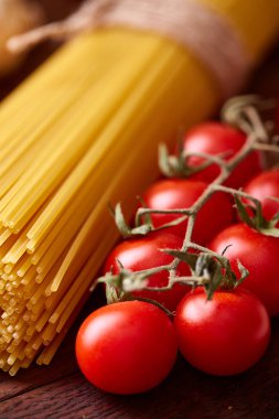 Pişmemiş makarna, domates ve baharat ahşap arka plan, üstten görünüm, yakın çekim, seçici odak