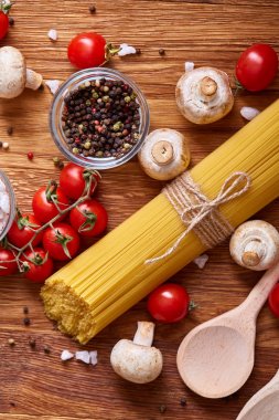 Pişmemiş makarna, domates ve baharat ahşap arka plan, üstten görünüm, yakın çekim, seçici odak