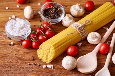 Pişmemiş makarna, domates ve baharat ahşap arka plan, üstten görünüm, yakın çekim, seçici odak