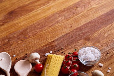 Pişmemiş makarna, domates ve baharat ahşap arka plan, üstten görünüm, yakın çekim, seçici odak