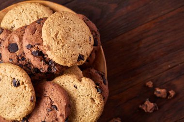 Rustik arka plan, seçici odak üzerinde ahşap bir tabakta çikolatalı kurabiye yan görünüm