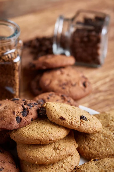 Side view of chocolate chip cookies on a wooden plate over rustic background, selective focus — Stock Photo, Image