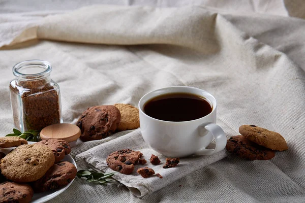 Breakfast background with mug of fresh coffee, homemade oatmeal cookies, grind coffee