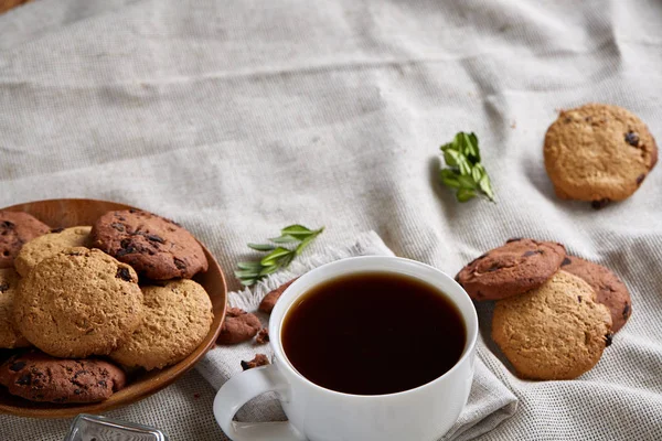 Café de la mañana en taza blanca, galletas de chispas de chocolate en el primer plano de la tabla de cortar, enfoque selectivo —  Fotos de Stock