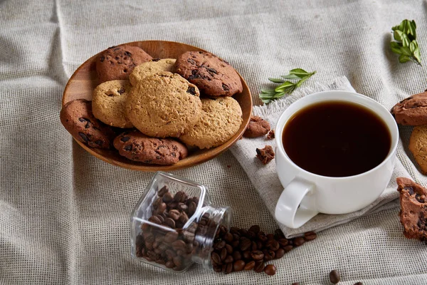 Café de la mañana en taza blanca, galletas de chispas de chocolate en el primer plano de la tabla de cortar, enfoque selectivo — Foto de Stock