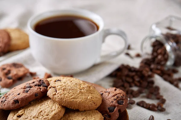 Café de la mañana en taza blanca, galletas de chispas de chocolate en el primer plano de la tabla de cortar, enfoque selectivo — Foto de Stock
