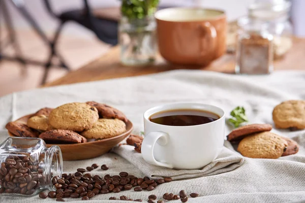 Café de la mañana en taza blanca, galletas de chispas de chocolate en el primer plano de la tabla de cortar, enfoque selectivo —  Fotos de Stock
