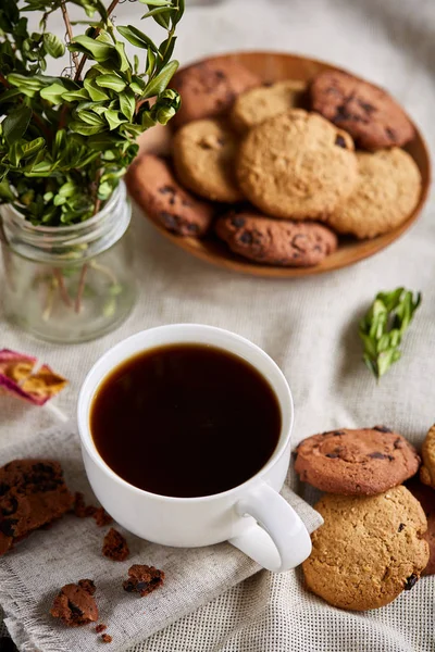 Morning coffee in white cup, chocolate chips cookies on cutting board close-up, selective focus — Stock Photo, Image