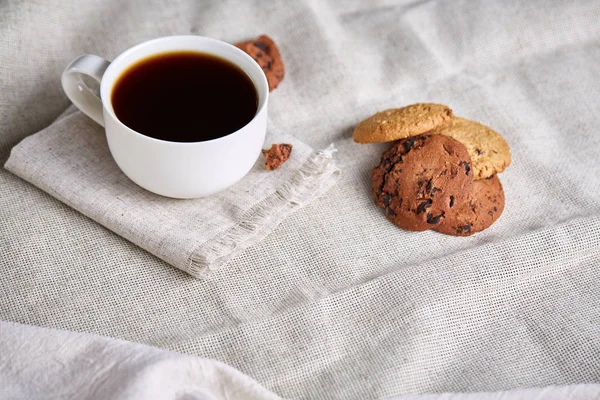 Morning coffee in white cup, chocolate chips cookies on cutting board close-up, selective focus — Stock Photo, Image