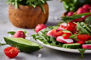 Bir vejetaryen salata beyaz dokulu arka plan, yakın çekim, seçici odak için sebzeli ahşap plaka