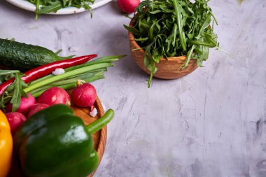 Bir vejetaryen salata beyaz dokulu arka plan, yakın çekim, seçici odak için sebzeli ahşap plaka