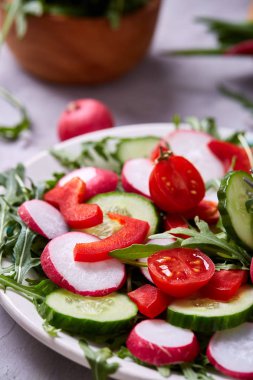 Bir vejetaryen salata beyaz dokulu arka plan, yakın çekim, seçici odak için sebzeli ahşap plaka