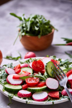 Bir vejetaryen salata beyaz dokulu arka plan, yakın çekim, seçici odak için sebzeli ahşap plaka