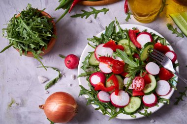 Bir vejetaryen salata beyaz dokulu arka plan, yakın çekim, seçici odak için sebzeli ahşap plaka