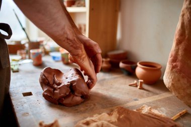 Yetişkin erkek potter usta kil plaka potters tekerlek üzerinde modelleme. Üstten Görünüm, portre, sadece eller.