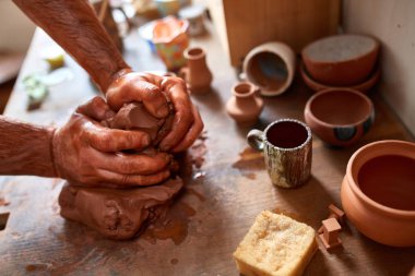 Yetişkin erkek potter usta kil plaka potters tekerlek üzerinde modelleme. Üstten Görünüm, portre, sadece eller.