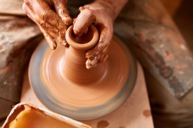Yetişkin erkek potter usta kil plaka potters tekerlek üzerinde modelleme. Üstten Görünüm, portre, sadece eller.