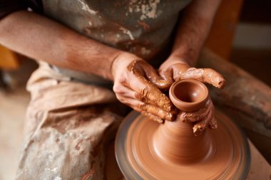 Yetişkin erkek potter usta kil plaka potters tekerlek üzerinde modelleme. Üstten Görünüm, portre, sadece eller.