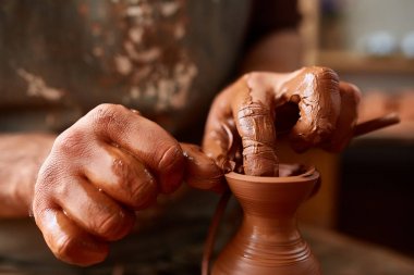 Yetişkin erkek potter usta kil plaka potters tekerlek üzerinde modelleme. Üstten Görünüm, portre, sadece eller.