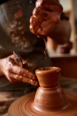Bir erkek potter önlük portresi kase kil, seçici odak, yakın çekim kalıpları