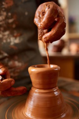 Yetişkin erkek potter usta kil plaka potters tekerlek üzerinde modelleme. Üstten Görünüm, portre, sadece eller.