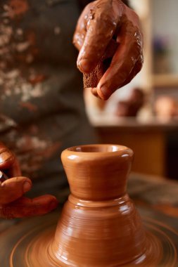 Yetişkin erkek potter usta kil plaka potters tekerlek üzerinde modelleme. Üstten Görünüm, portre, sadece eller.