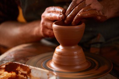 Yetişkin erkek potter usta kil plaka potters tekerlek üzerinde modelleme. Üstten Görünüm, portre, sadece eller.