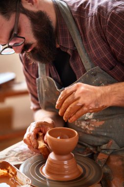 Bir erkek potter önlük portresi kase kil, seçici odak, yakın çekim kalıpları