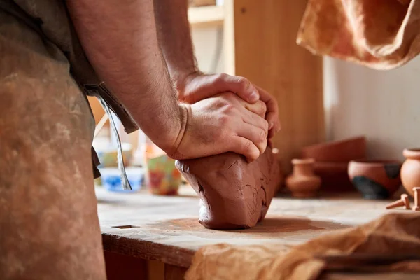 Dospělý samec potter master modelování hliněné desky na hrnčíři kola. Pohled shora, closeup, ruce pouze. — Stock fotografie