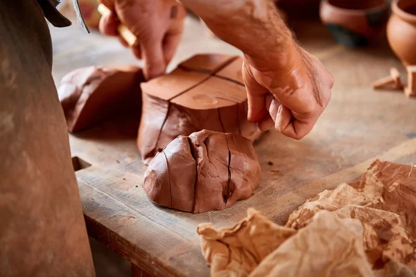 Vuxna manlig potter master modellering lera plattan på keramiker hjul. Ovanifrån, närbild, händerna bara. — Stockfoto