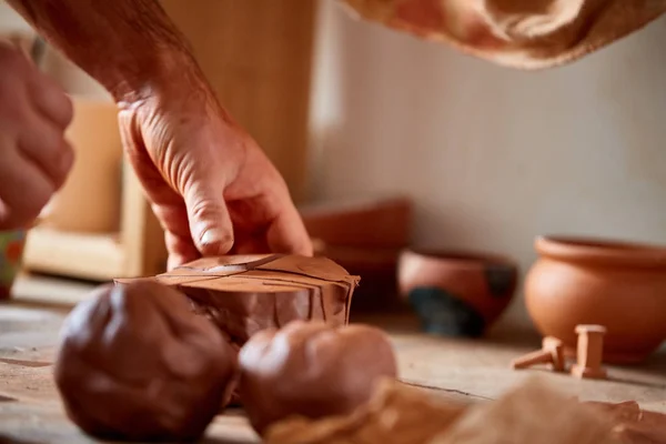 Dorosły mężczyzna potter master modelowania gliny płytkę na potters wheel. Widok z góry, zbliżenie, ręce tylko. — Zdjęcie stockowe