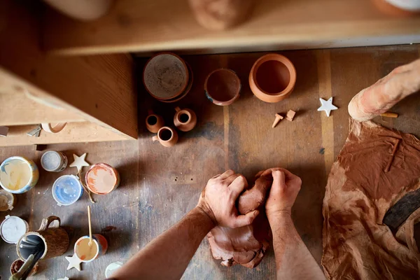 Dorosły mężczyzna potter master modelowania gliny płytkę na potters wheel. Widok z góry, zbliżenie, ręce tylko. — Zdjęcie stockowe