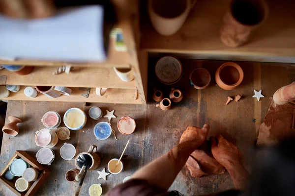 成年男波特大师建模陶轮上的粘土板。顶部视图, 特写, 仅手. — 图库照片
