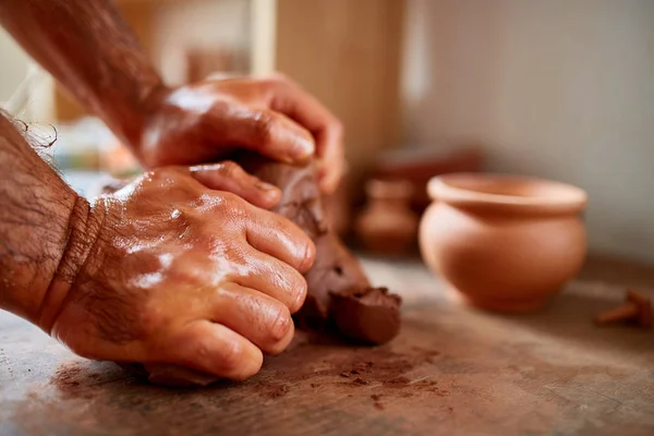 Maestro di vasaio maschio adulto che modella la piastra di argilla sulla ruota dei vasai. Vista dall'alto, primo piano, solo le mani . — Foto Stock