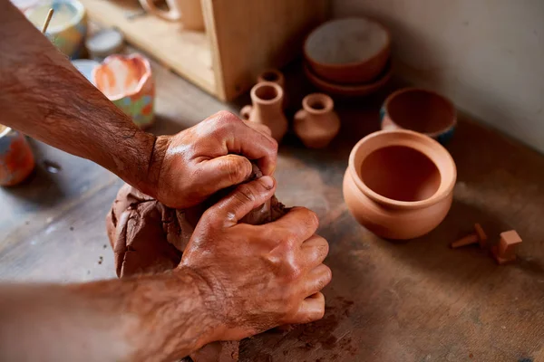 Dorosły mężczyzna potter master modelowania gliny płytkę na potters wheel. Widok z góry, zbliżenie, ręce tylko. — Zdjęcie stockowe