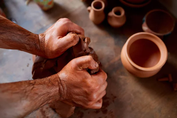 Volwassen mannelijke potter meester de kleiplaat modelleren op potters wiel. Bovenaanzicht, close-up, handen alleen. — Stockfoto