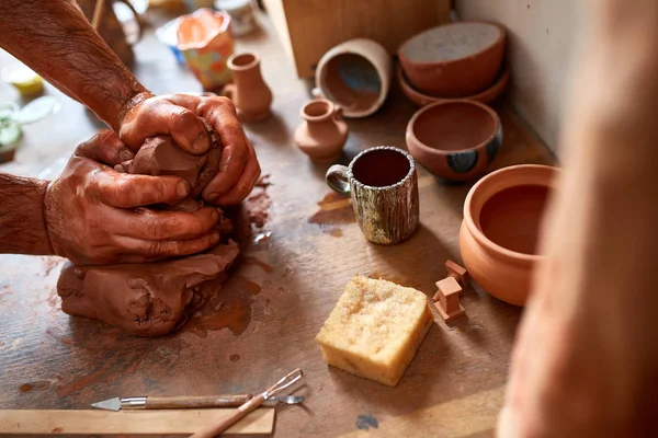 Dorosły mężczyzna potter master modelowania gliny płytkę na potters wheel. Widok z góry, zbliżenie, ręce tylko. — Zdjęcie stockowe