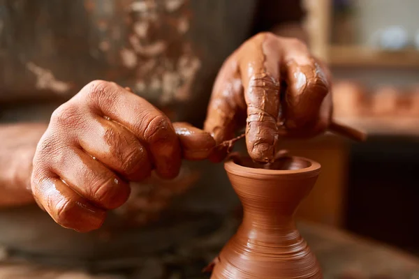 Volwassen mannelijke potter meester de kleiplaat modelleren op potters wiel. Bovenaanzicht, close-up, handen alleen. — Stockfoto