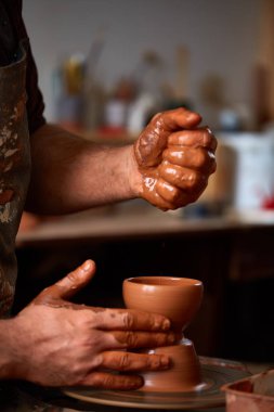 Yakın çekim eller erkek Potter Clay, seçici odak bir vazo yapma önlük